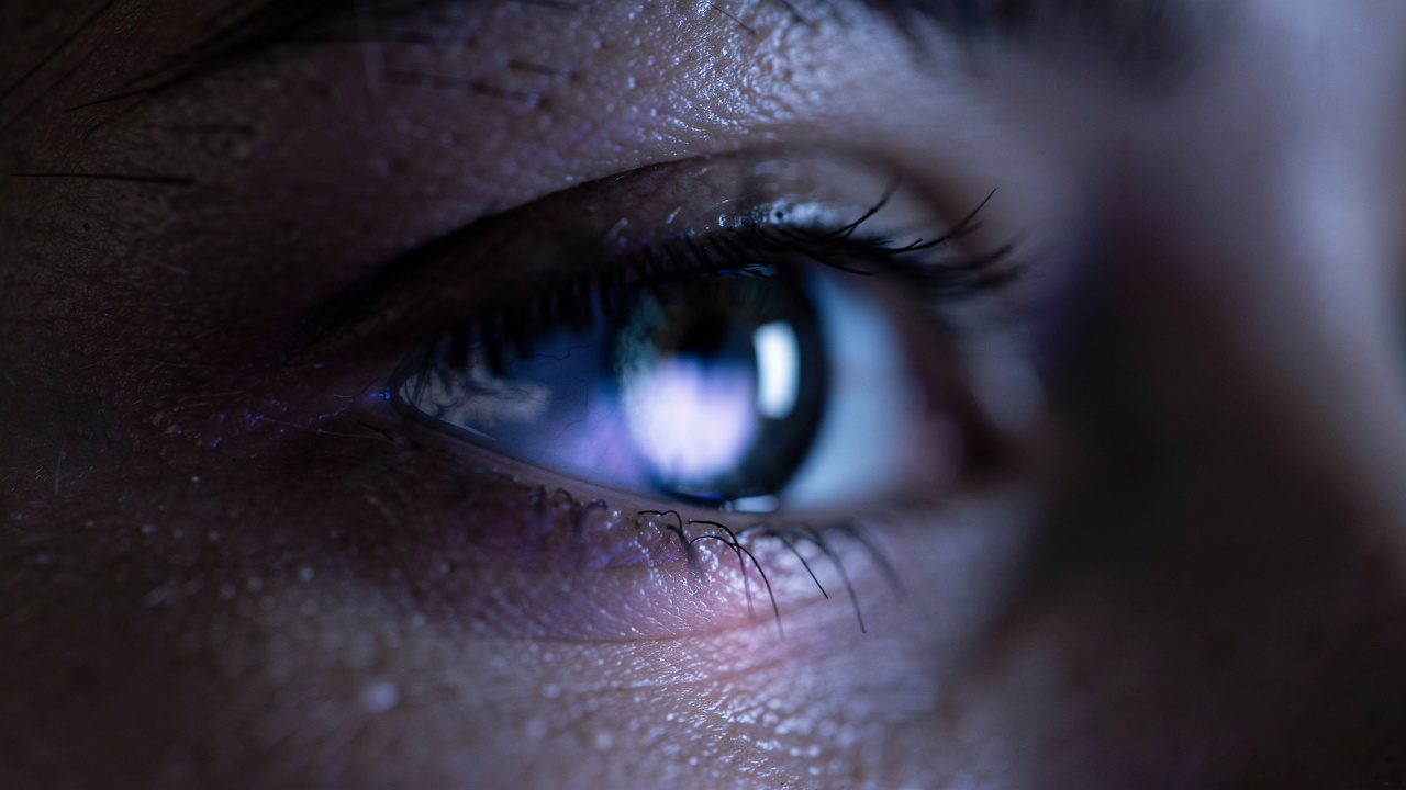 Eye reflecting flickering light from a television screen